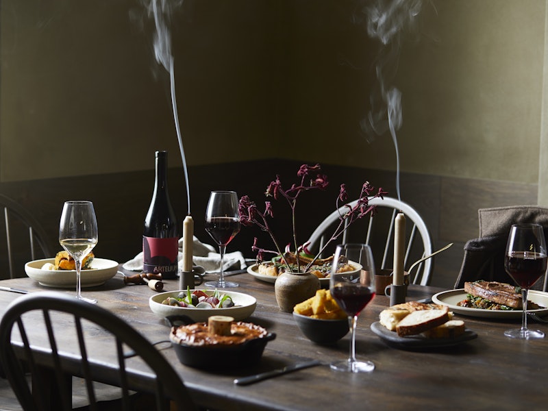 A table spread of food and wine at The Penny Bun inn and pub in Ilkley, England