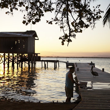 Fisherman cleaning fish on jetty at Tobacco Caye.