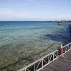 THATCH CAYE, BELIZE. A woman wearing a red sun dress walks on a wooden pier over crystal clear water and a blue sky above.
564189675
40-44 Years, 40s, Adult, belize, Boardwalk, Central America, color image, Copy Space, day, Full Length, Getting Away From It All, Horizon Over Water, Horizontal, idyllic, latin america, Looking At View, Mature Adult, Mature Women, One Person, outdoors, photography, Rear View, relaxation, Sea, Selective Focus, Sky, sundress, Thatch Caye, travel, Travel Destinations, Tropical Climate, Vacations, water, women, wood