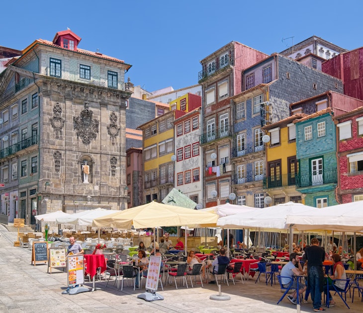 PORTO, PORTUGAL - JUNE 5, 2015: Colorful houses and outdoor cafes at historic Ribeira Square of Porto, a popular place for tourists and locals., License Type: media, Download Time: 2025-02-25T21:56:50.000Z, User: katelyn.perry_lonelyplanet, Editorial: true, purchase_order: 65050 - Digital Destinations and Articles, job: wip, client: wip, other: katelyn perry