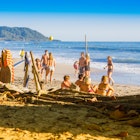 Santa Teresa, Costa Rica - June, 28, 2018: Tourists sitting in the sand and enjoying the beautiful view of Santa Teresa beach, and some surfers check out the conditions to surf  License Type: media  Download Time: 2023-04-05T01:12:47.000Z  User: mvm_lonelyplanet  Is Editorial: Yes  purchase_order:   