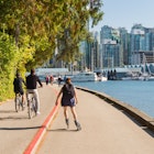 September 14, 2017: Cyclists and a rollerblader on a path in Stanley Park during summer.